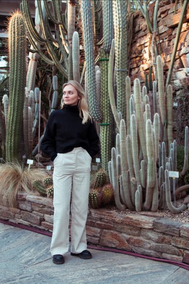 full frontal einer Frau im botanischen Garten, im Hintergrund sind Kaktäen und Natursteinmauern zu sehen