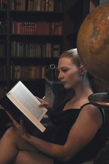 Buch lesende Frau in der Bibliothek
